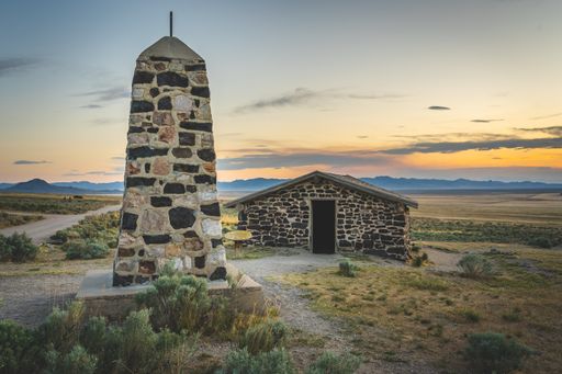 Old cabin and marker at a horse trail in an evening with the sunlight and dark clouds