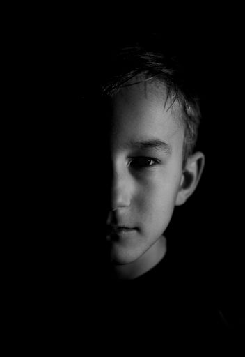 A Young Caucasian  boy portrait against black background