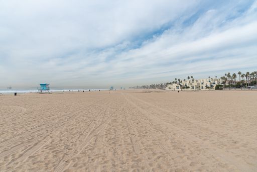 Landscape view of Huntington Beach in winter with lifeguard towers and very few people