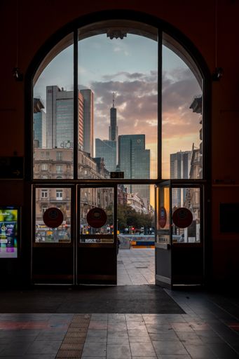 A vertical shot of main entrance of a glass door in Frankfurt main station during sunset