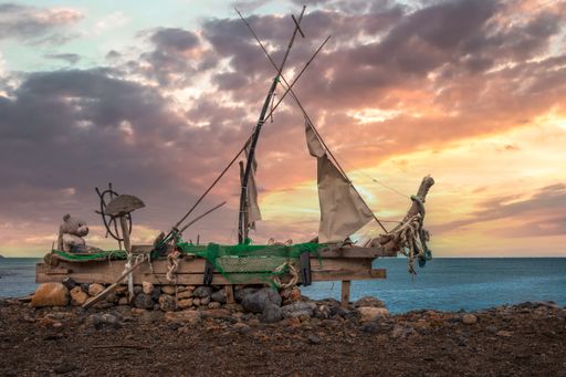 An old garbage ship with a teddy bear on the beach of Crete Island, Greece, during sunset
