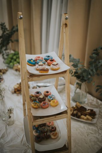 A plate of donuts with colorful creamy decoration for an event