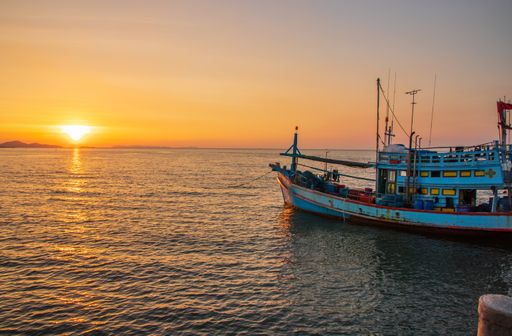 A Thai fishing boat at a pier in the early evening during sunset time