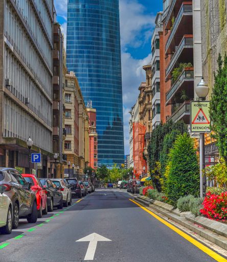 A vertical shot of a road leading to a skyscraper