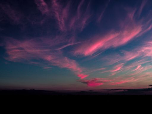 A beautiful wide shot of a dark sky with pink clouds