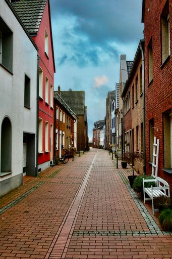 A vertical shot of a narrow street with colorful buildings