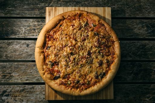A high angle shot of a freshly baked pizza on a wooden surface