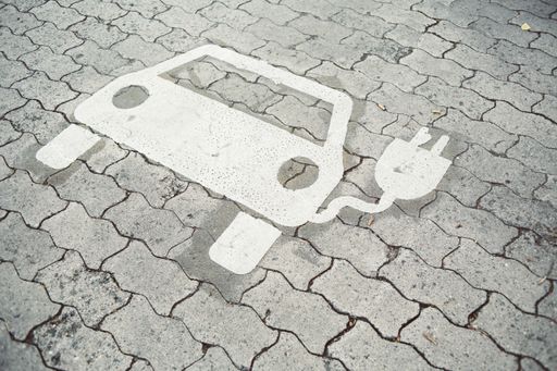 The painted sign of a hybrid car charging space on the pavement