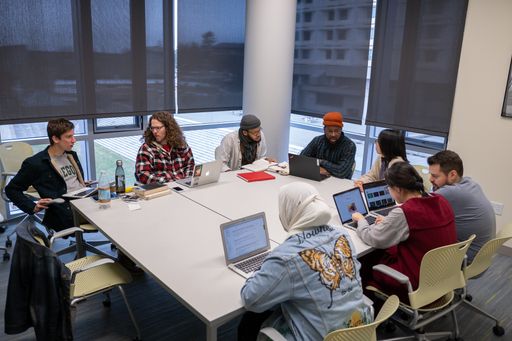A close-up shot of college students sitting around a table and communicating