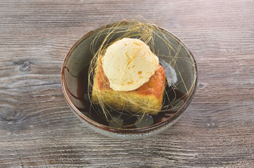 A closeup shot of a cake with an ice cream on the wooden table