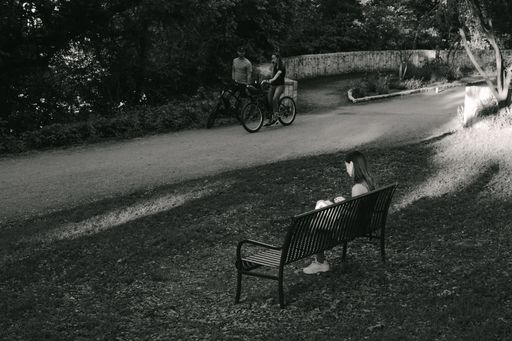 A girl sitting on a park bench reading a book