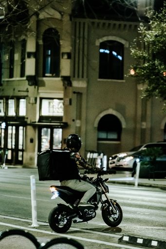 A vertical shot of a delivery driver at night in Austin, United States
