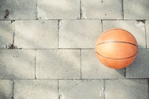 A high angle shot of a basketball ball on the pavement