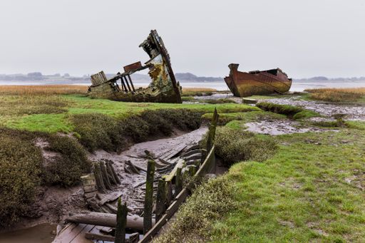 A cloeup shot of ruined, abandoned boats on the banks of the river