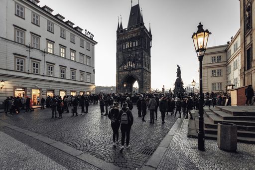The square in front of Charles Bridge in Prague on New Year's Eve after sunset. The streetlights are shining.
