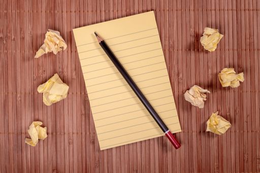 A top view of the notepad, pencil and crumpled paper on an office desk, business creative concept
