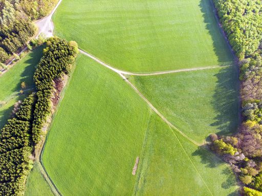 A drone photography of beautiful green fields of the countryside on a sunny day