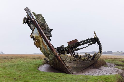 A cloeup shot of ruined, abandoned boats on the banks of the river