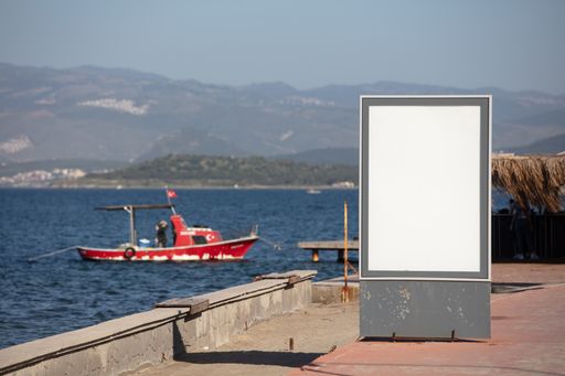 A landscape shot of advertisement stand in front of a lake