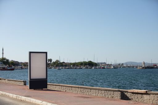 A landscape shot of advertisement stand in front of a lake