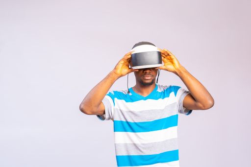 A young African man using virtual reality headset isolated on a white background