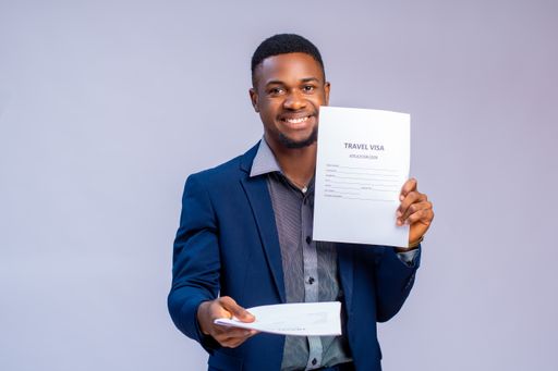 A cheerful young travel agent holding a visa application form