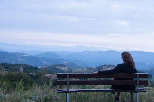 A female sitting on the bench and enjoying the beautiful view of the countryside landmark
