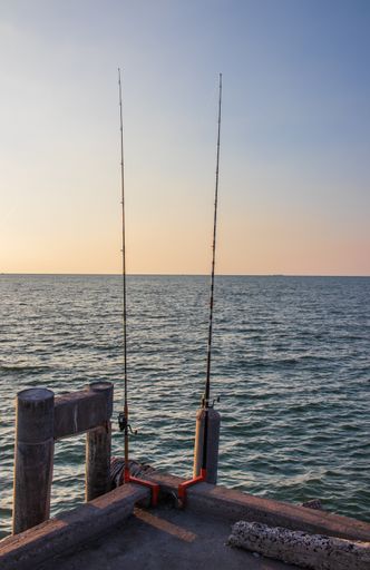 A nice angler's place with his fishing rods right on the pier from the sea