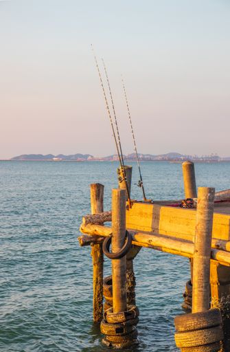 A nice angler's place with his fishing rods right on the pier from the sea