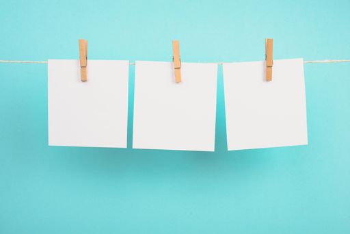 Empty white sheets of paper in a row hanging on a string, copy space for pictures and text, message communication and marketing background, blue color