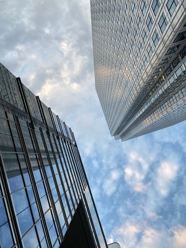 A low angle shot of glass skyscrapers under the cloudy skies