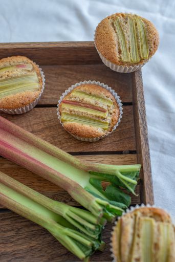 A vertical shot of the homemade rhubarb muffins just taken from the oven on the wooden tray