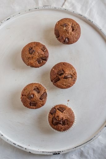 A vertical top view of the homemade chocolate muffins just taken from the oven on the white plate