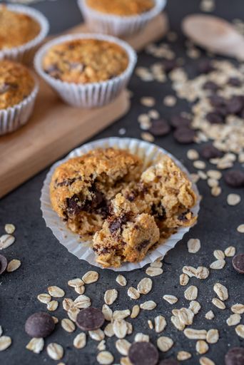 A vertical closeup shot of the homemade chocolate muffins just taken from the oven on the wooden board