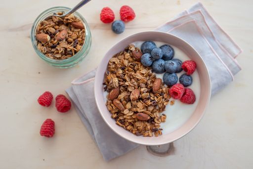 A healthy breakfast with a bowl of granola, yogurt and fresh berries