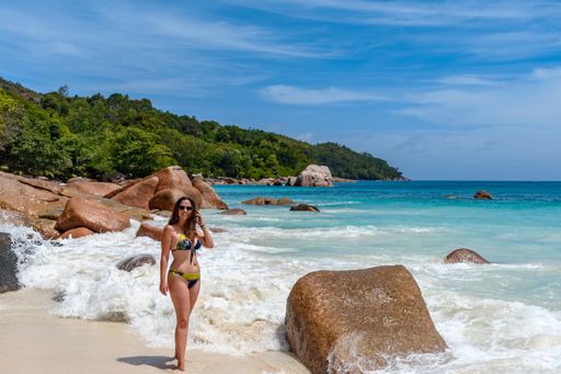 A sexy female wearing a bikini on the Anse Lazio beach on a tropical island in Seychelles