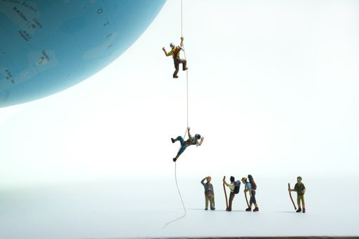 a group of mountaineers watches climbers pulling themselves up on a globe with a rope. white background