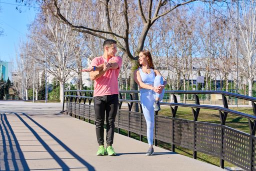 A Caucasian couple doing yoga in a park