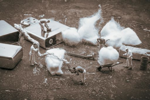 A closeup shot of small working figurines with cotton balls