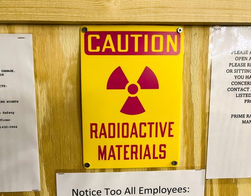 A caution Radioactive Materials yellow-colored sign with red letters on a wooden box