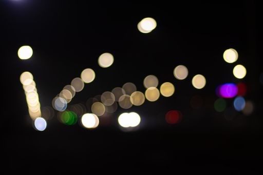 A blurry background with bokeh lights outdoors at night for textures and wallpapers