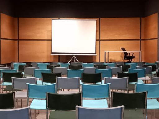 shot of a modern empty classroom or conference room with seats and a blank whiteboard for mockup. Education. Copyspace