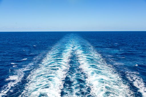 A mesmerizing shot of blue ocean waves of a cruise ship