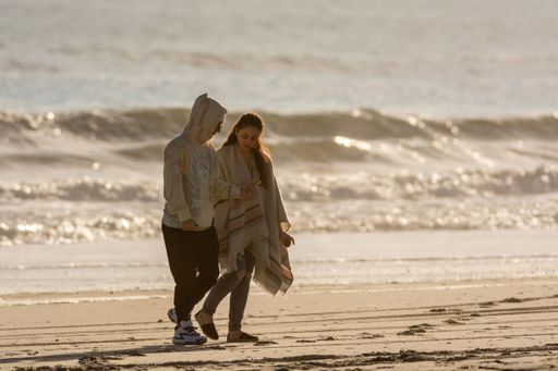A beautful view of a couple Walking along the sunny beach in Emerald Isle, North Carolina