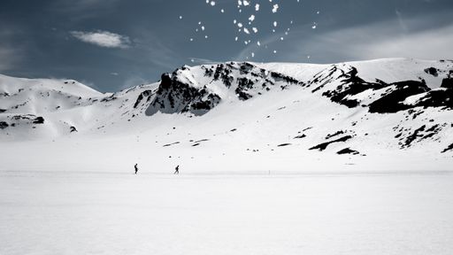 A wide shot of mountains covered in snow under a cloudy sky
