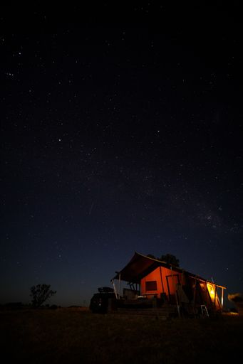 A small wooden camp house under the milky way sky