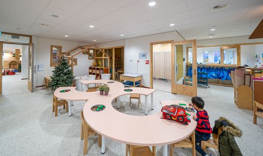A Panoramic shot of the inner square in a primary school with a sitting child studying.