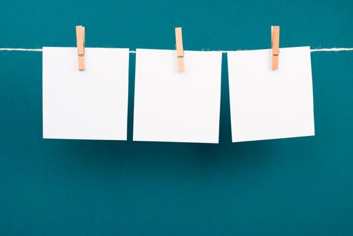 Empty white sheets of paper in a row hanging on a string, copy space for pictures and text, message communication and marketing background
