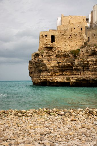 A vertical shot of the old buildings on the shore. Lama Monachile, Polignano a Mare, Italy.