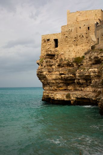 A vertical shot of the old buildings on the shore. Lama Monachile, Polignano a Mare, Italy.